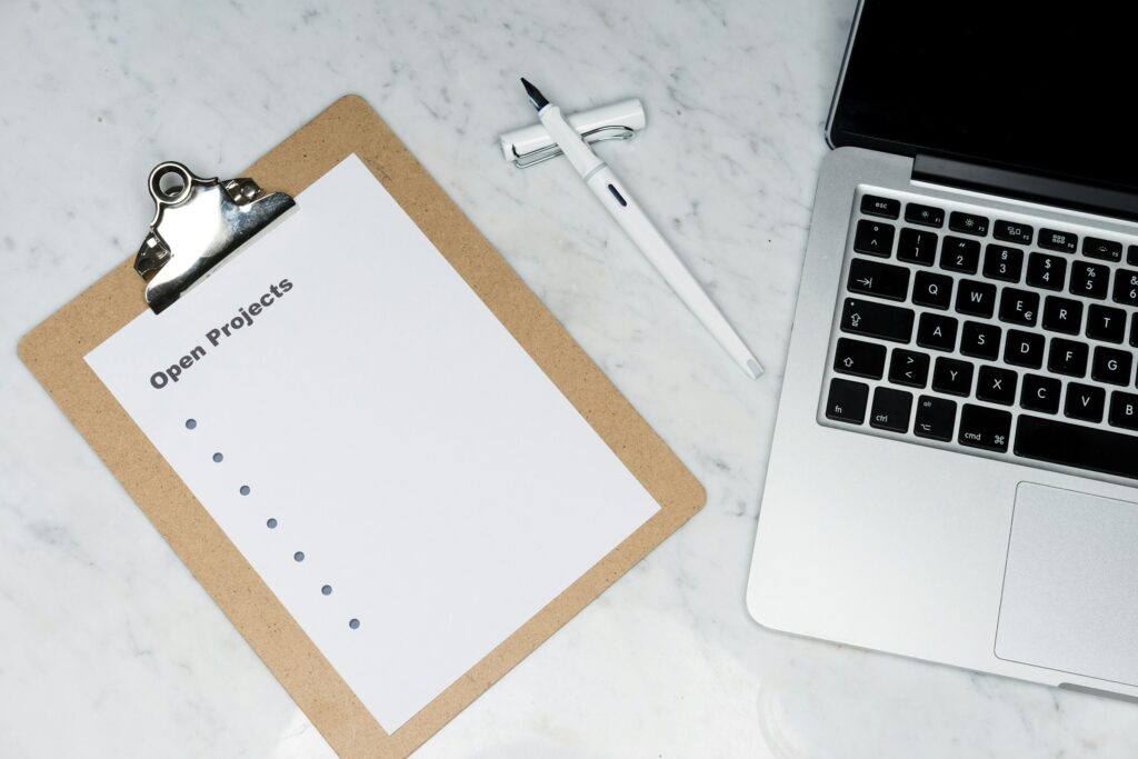 Clipboard and laptop used to organize risk and compliance requirements for business operations